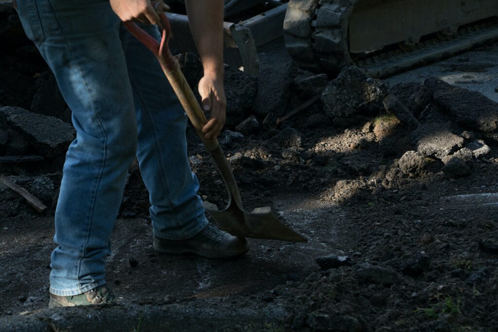 Close up of a worker digging dirt while landscaping - Iverson Forest Management Landscaping & Property Services
