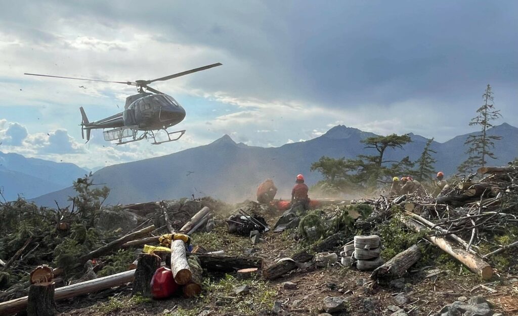 A helicopter landing at a wildfire base camp - Iverson Forest Management Wildfire Services